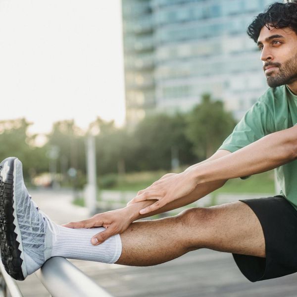 A man stretching outdoors at sunrise, feeling energized and focused.