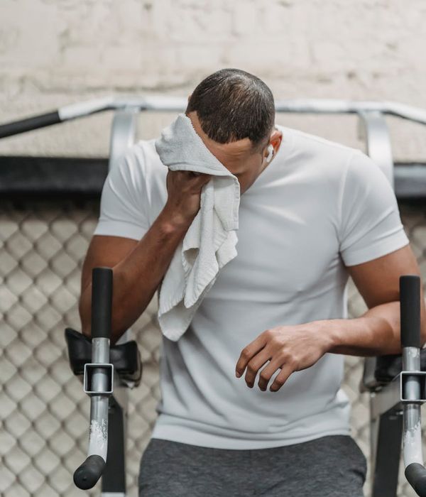 Man performing a strength exercise in a modern, well-lit gym.